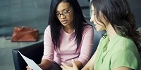 Two women looking at a document together