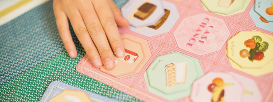 A child's hand as they play with an association puzzle.