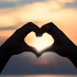 Heart formed by silhouette of hands, symbolizing caring
