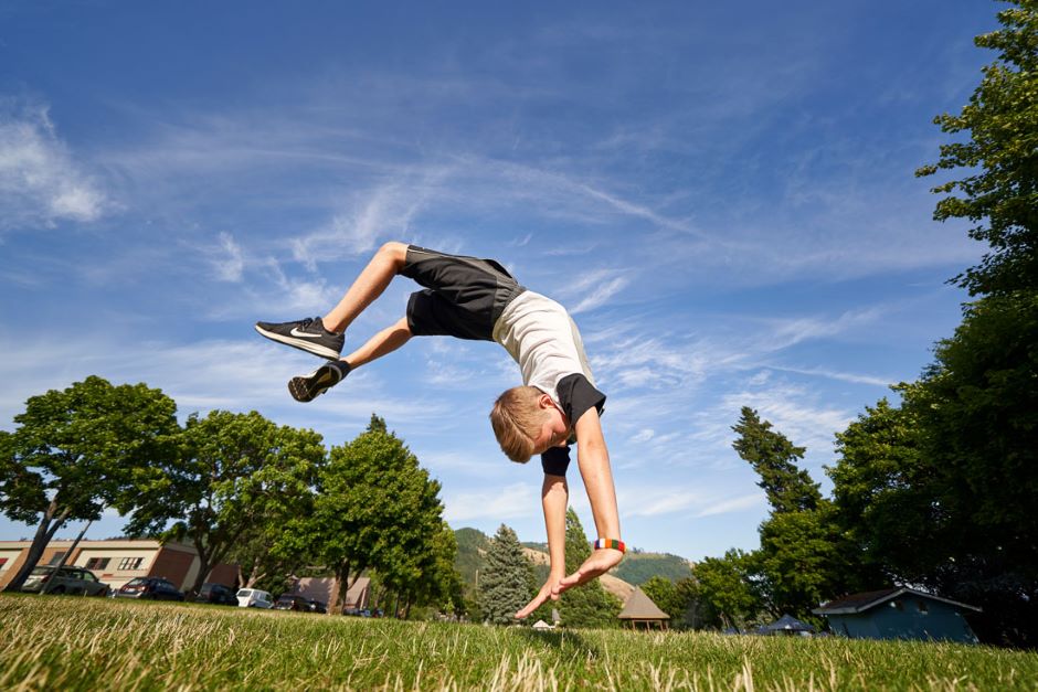 Sawyer does a backflip in the grass.