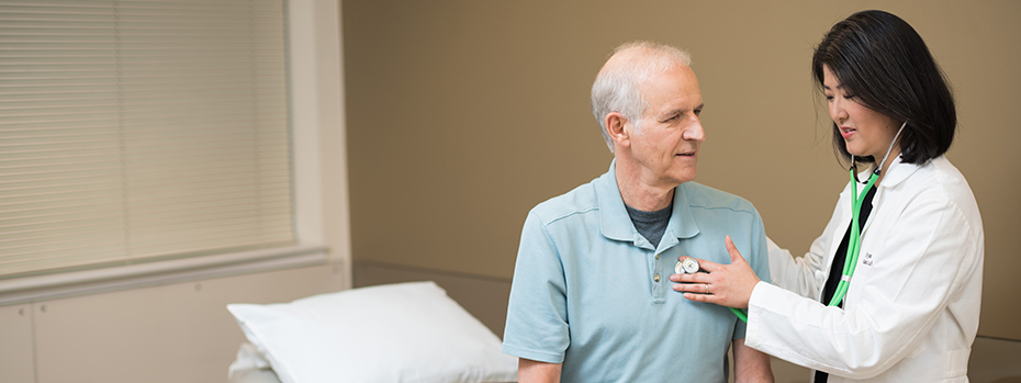 Vascular surgeon Dr. Enjae Jung listens to a patient’s heart.