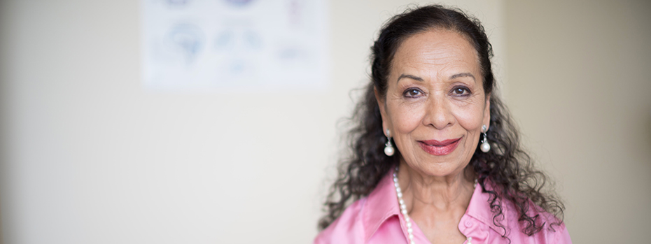 Photograph of a woman in a pink blouse smiling