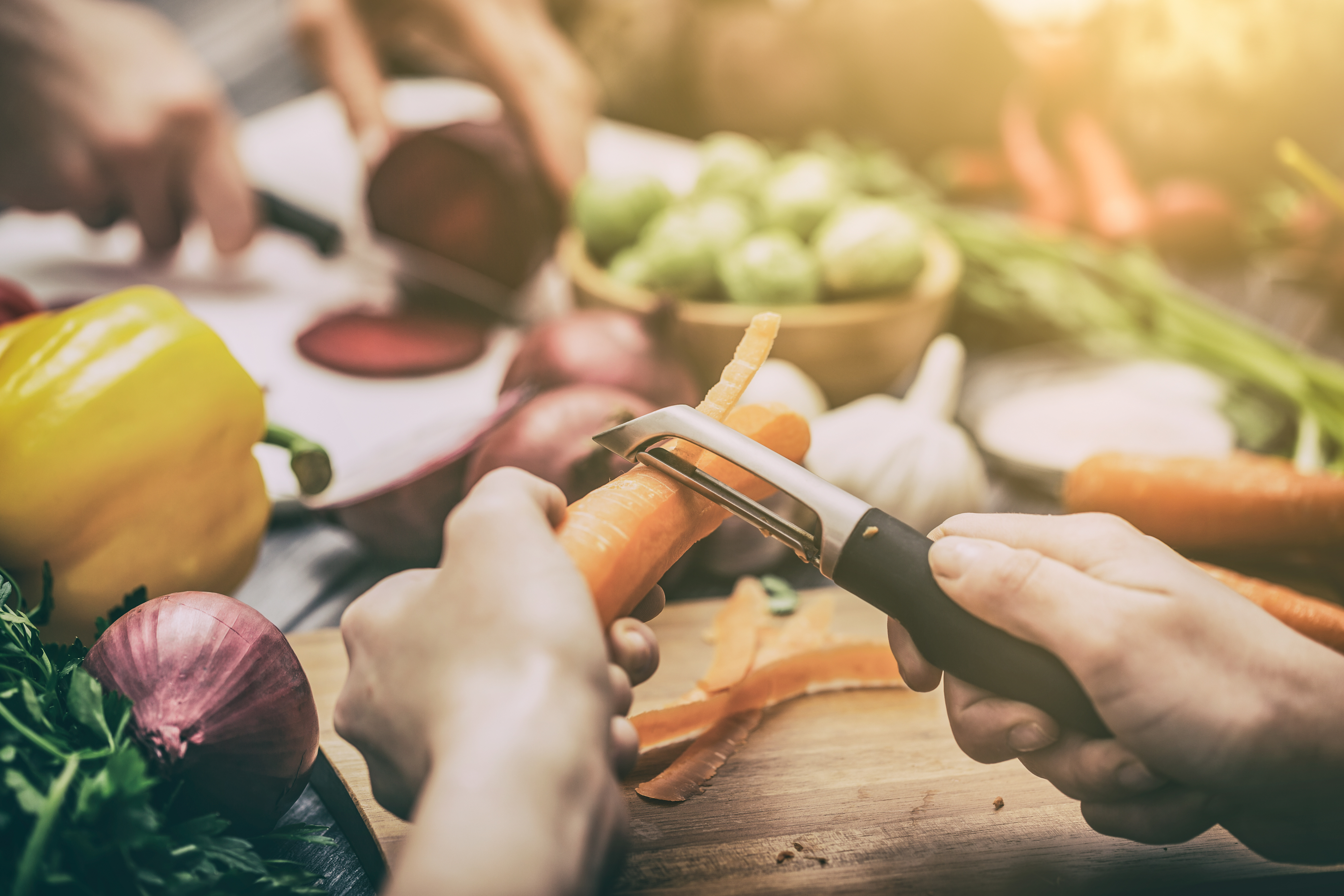two hands peeling vegetables