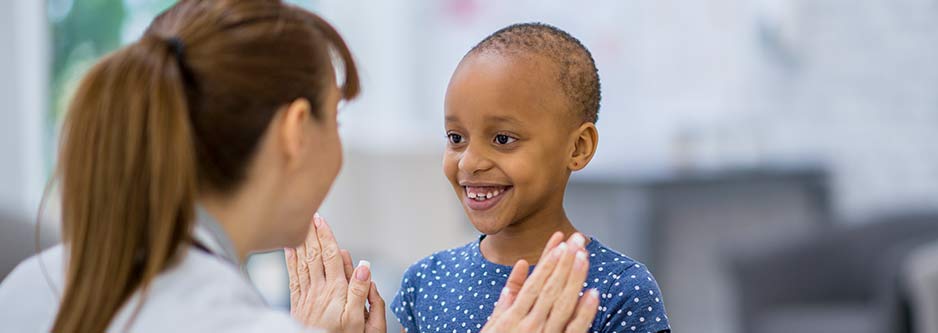 A smiling child and healthcare provider.