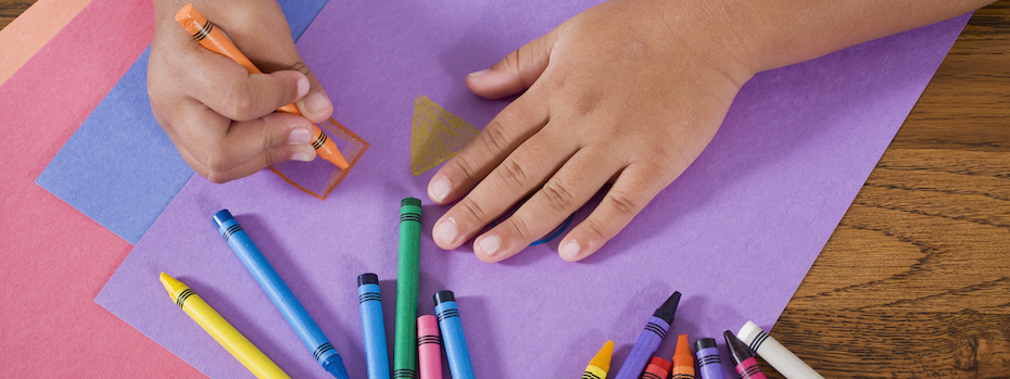 A child draws with crayons.