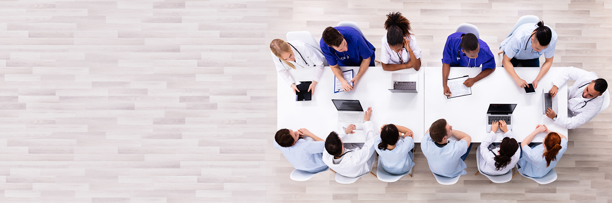 Positive Young Specialists With Stethoscope Having Discussion Of Research Work In Conference Room