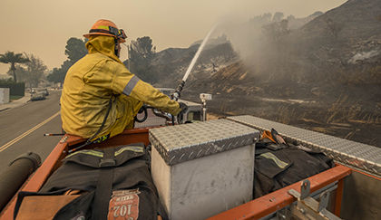 Scott Eyer sprays water to a hill at the Porter Ranch neighborhood in Los Angeles, Calif.