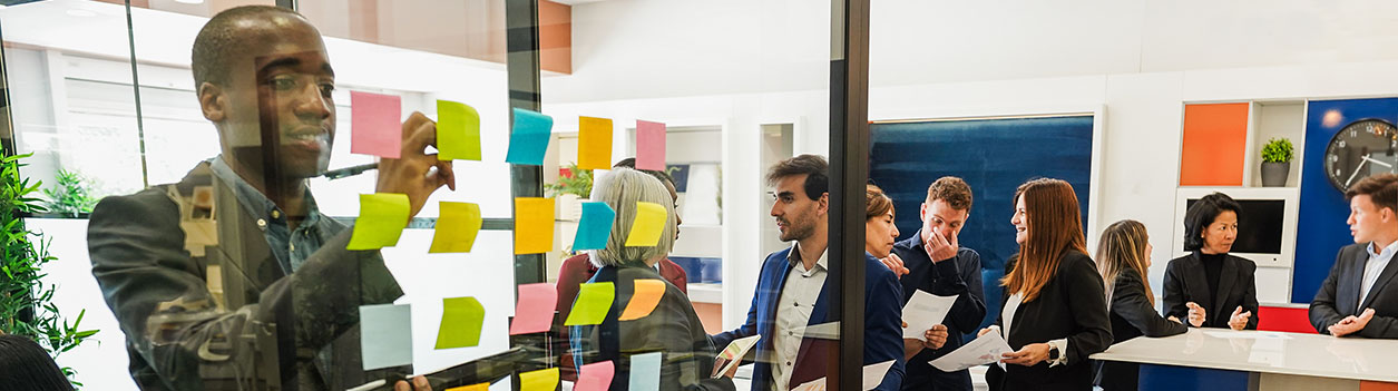 Multiracial colleagues working inside business office with glass walls