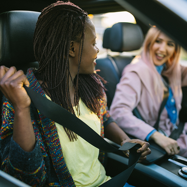 Two people in a carpool smiling