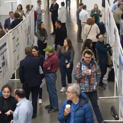 photo from above of a crowd of people with rows of research posters. 