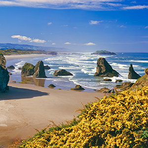 A view of Coos Bay showing the rocks near the shore and a few clouds in the sky.