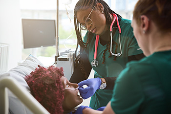 Two OHSU nursing students wearing scrubs review patient information.
