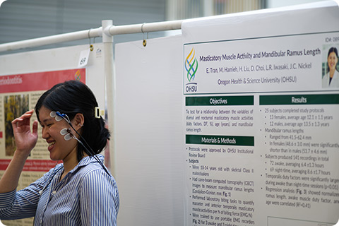 A student demonstrates research on masticatory muscle activity