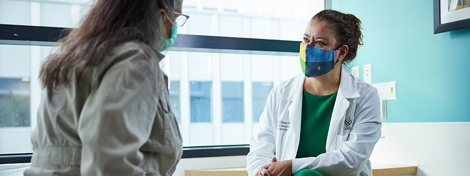 An OHSU breast cancer expert listens to a patient in an exam room.