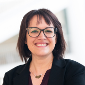 Smiling woman in headshot, wearing glasses