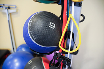 Exercise balls and resistance bands hanging in a gym. 