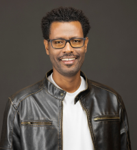 Headshot of Fikadu Tafesse, smiling in a leather jacket 