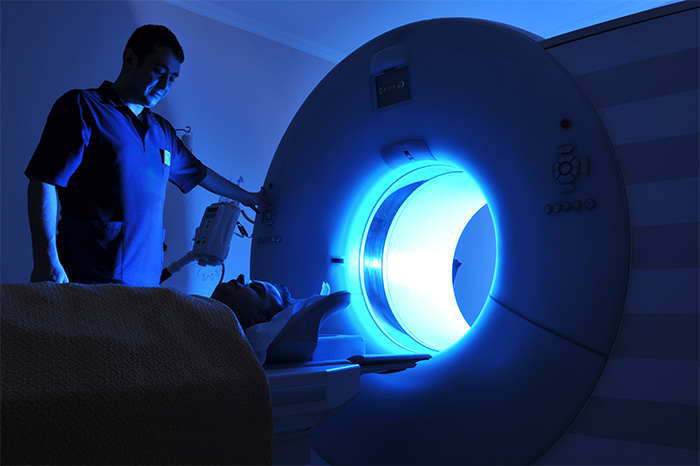 Health care professional positioning a patient for a scan.