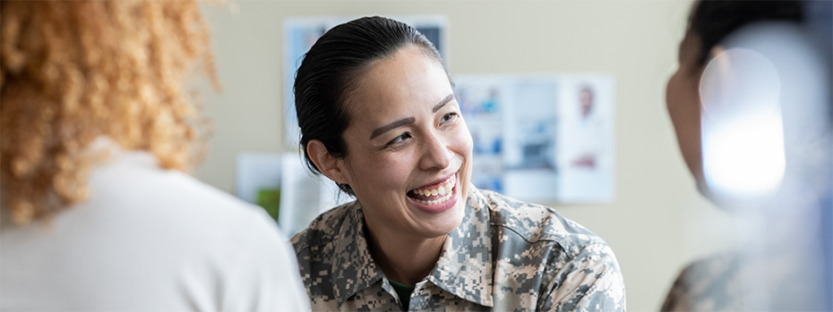 An OHSU student veteran smiles while sitting with classmates.
