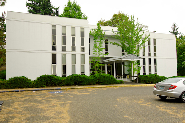 White building with a parking lot in front of it