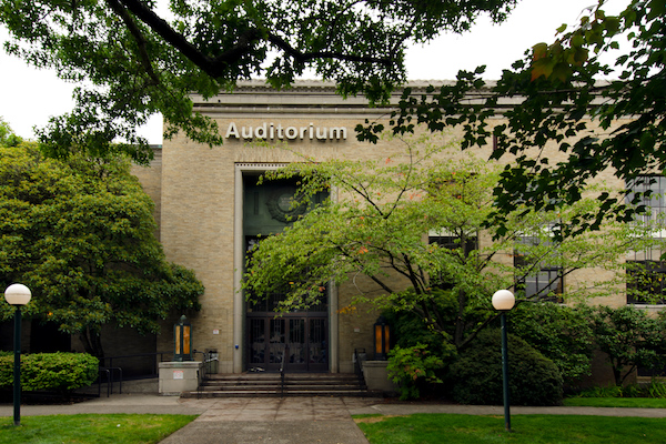 Brick building surrounded with trees with an Auditorium sign on the outside