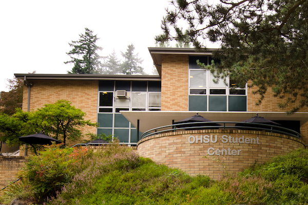 Brick building with a rounded balcony with OHSU Student Center sign on it